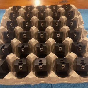 Updated black aluminum Cobra-Grille mounting blocks arranged in a tray