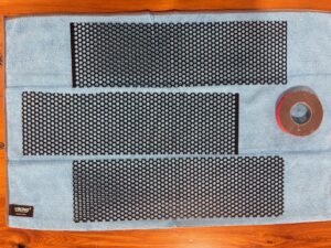 Black perforated aluminum DIY screen blanks with a roll of double-sided mounting tape